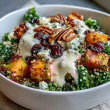 In this Harvest Kale Quinoa Bowl, golden sweet potatoes and crunchy pecans mingle with tangy blue cheese and sweet cranberries.
