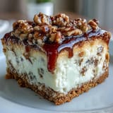 Creamy carrot cake cheesecake bars swirled with spiced carrot cake and vanilla cheesecake, topped with tangy cream cheese frosting.