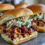 Tender shredded BBQ chicken and crisp coleslaw served on golden slider buns, ideal for 4th of July cookouts.  