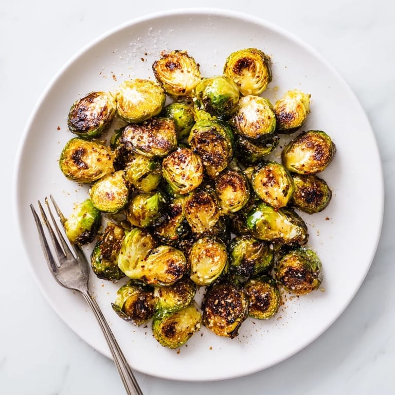 Roasted Brussels Sprouts paired with lemon wedges and parmesan on a rustic plate for a delicious vegetarian side.