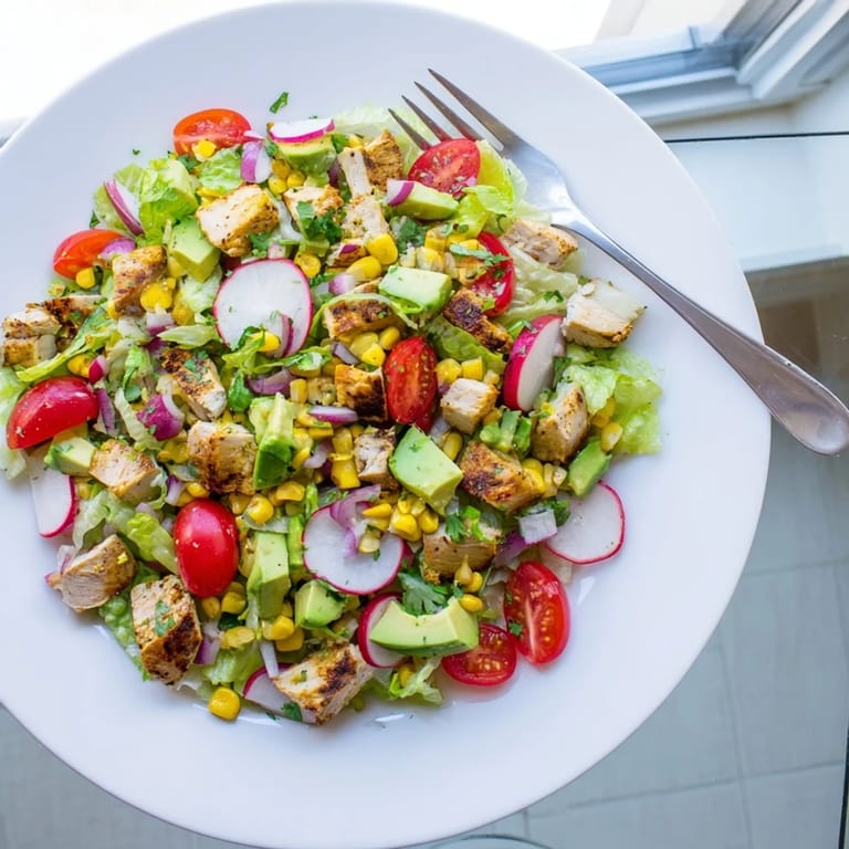 A close-up of Roasted Corn & Chicken Chopped Salad, featuring crisp romaine, juicy tomatoes, and radishes, perfect for an easy, gluten-free summer dinner.