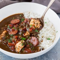 A steaming bowl of Louisiana Gumbo packed with andouille sausage and shrimp over fluffy white rice.
