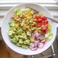 Freshly grilled chicken, charred corn, and creamy avocado tossed in a zesty lime dressing, making a vibrant Roasted Corn & Chicken Chopped Salad.