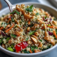 Vibrant Thai coconut quinoa bowl with creamy quinoa, crisp veggies, and zesty peanut dressing for a nourishing meal.